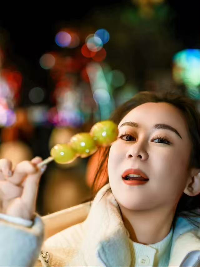 宝疙瘩拿着糖葫芦的夜景人像