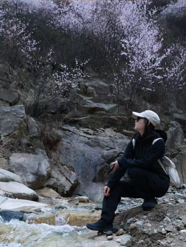 宝疙瘩坐在开满花的溪边